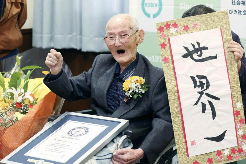 Chitetsu Watanabe, de 112 años, posa junto a un cartel que escribió tras ser condecorado como el hombre más viejo del mundo. (AP)