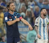 El volante croata Luka Modric (izquierda) ajusta su brazalete frente al delantero argentino Lionel Messi.