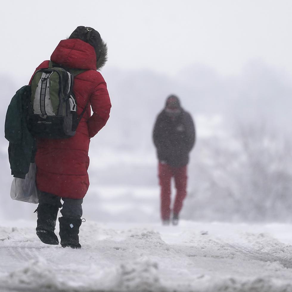 Dos personas caminan sobre la nieve el martes en la ciudad de Kansas City.