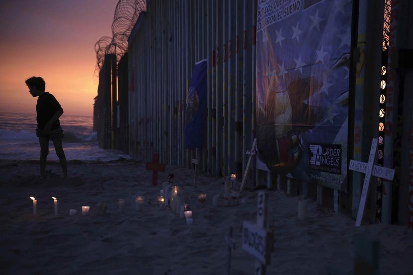 Un adolescente junto a la valla que divide Estados Unidos y México. (AP/Emilio Espejel)