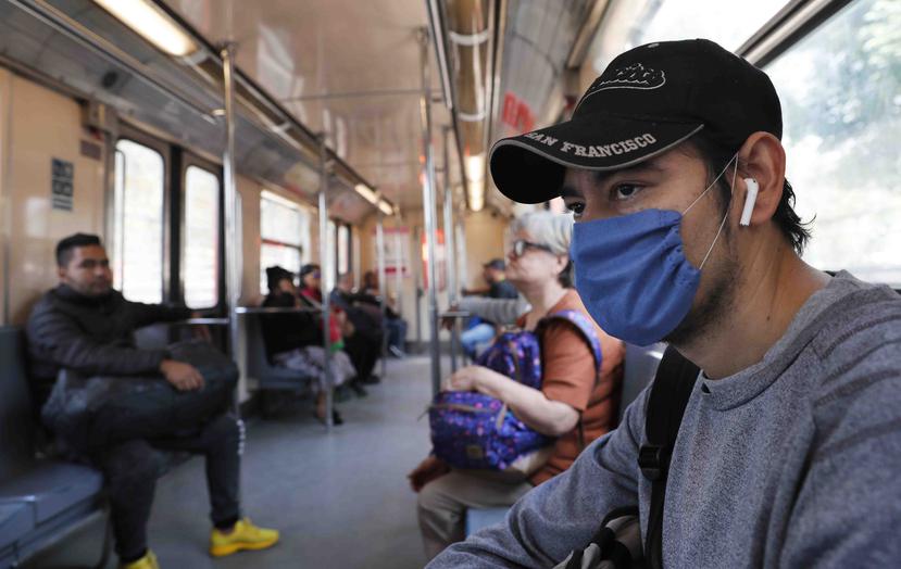 Un hombre usa una mascarilla protectora como medida de precaución de salud en un vagón del metro de la Ciudad de México. (AP)