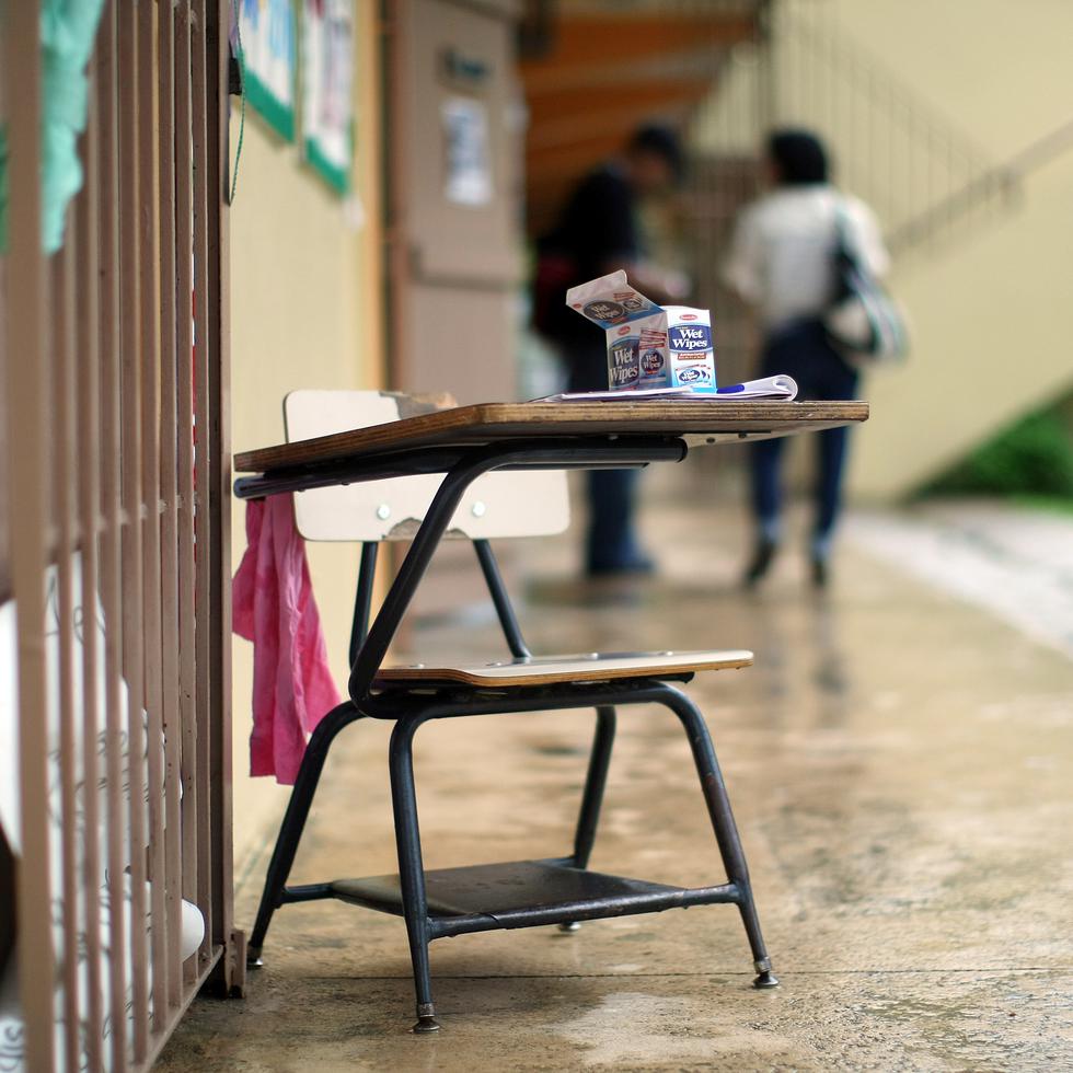 Foto de archivo de un pupitre en el pasillo exterior de una escuela.