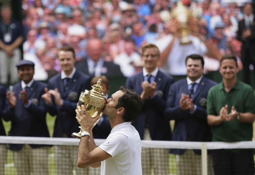 El suizo Roger Federer besa el trofeo de Wimbledon tras derrotar al croata Marin Cilic en la final. (AP / Tim Ireland)
