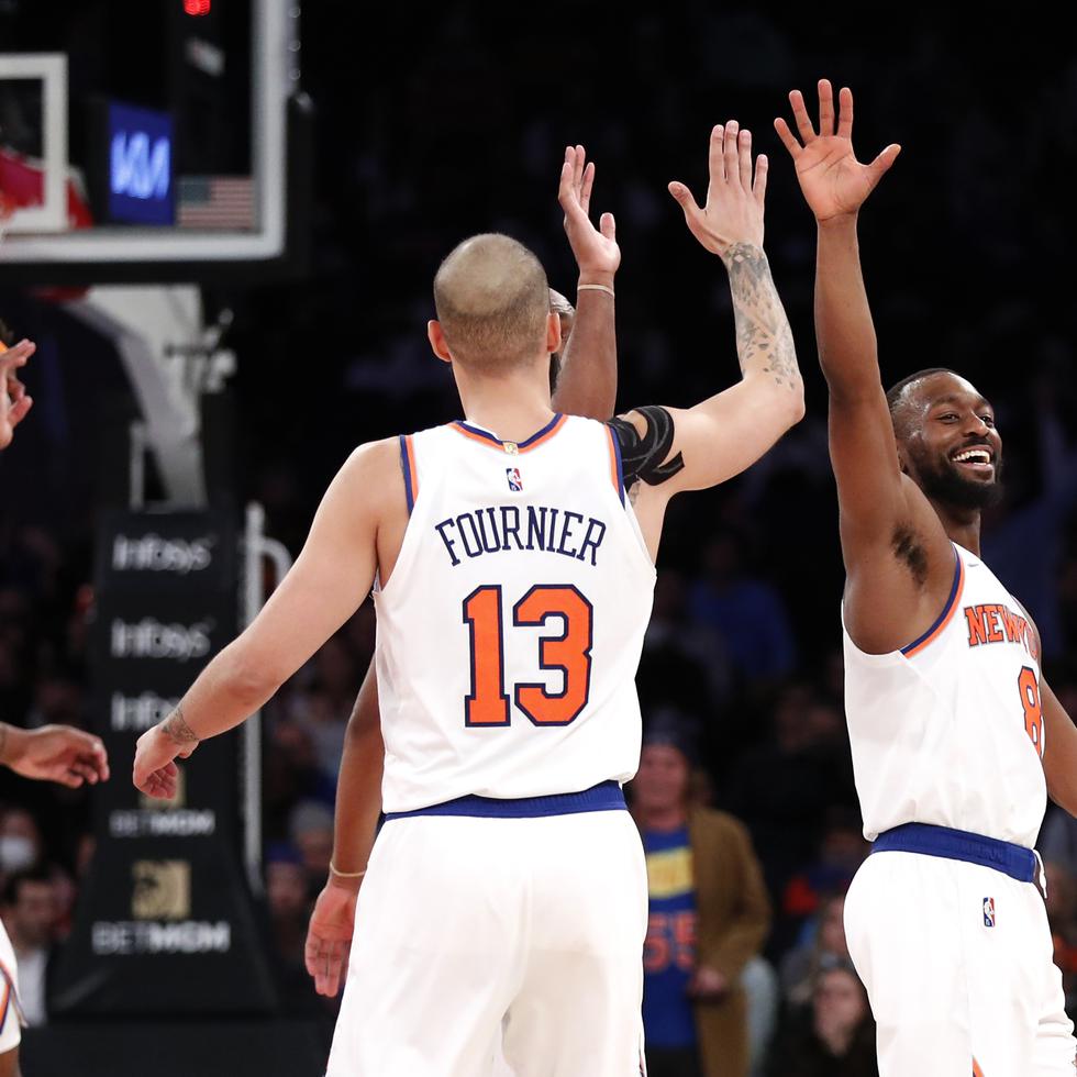 Kemba Walker (derecha), de los Knicks de Nueva York, festeja con Evan Fournier, luego de atinar un triple ante los Pistons de Detroit.