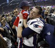 El mariscal de campo de los Patriots Tom Brady alza en brazos a su hijo, Ben, durante la celebración del triunfo sobre los Rams de Los Ángeles en el Super Bowl LIII. (AP / Mark Humphrey)