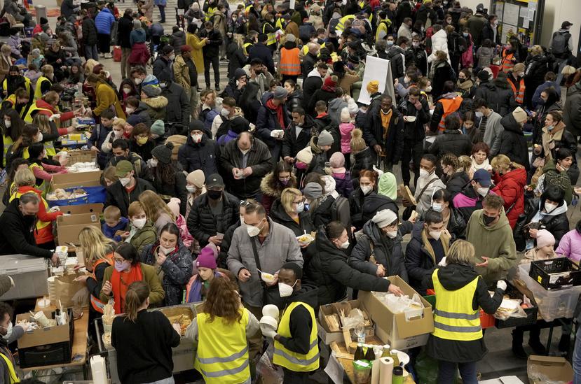 Refugiados ucranianos hacen fila para recibir comida a su llegada a la estación principal de trenes en Berlín, Alemania.