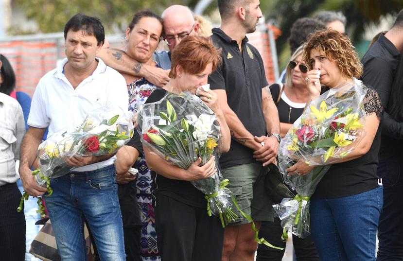 Familiares de las víctimas llevan flores durante el homenaje celebrado un mes después del derrumbe del puente Morandi, en Génova, Italia. (EFE)