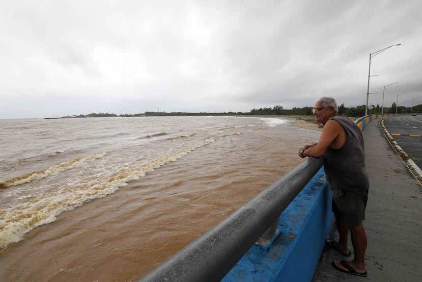 Una persona observa la costa de Arecibo, enlodada por las aguas del río grande de ese pueblo.