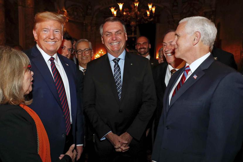 Bolsonaro, al centro, posa con el presidente Donald Trump, y el vicepresidente Mike Pence. Detrás de Trump y parcialmente cubierto, el director de prensa de Bolsonaro y quien arrojó positivo.  (AP)