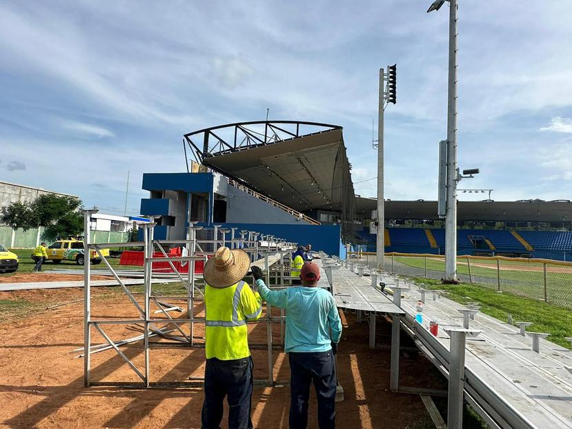Empleados del Municipio de Camuy laboran en la instalación de gradas en el jardín derecho del estadio.