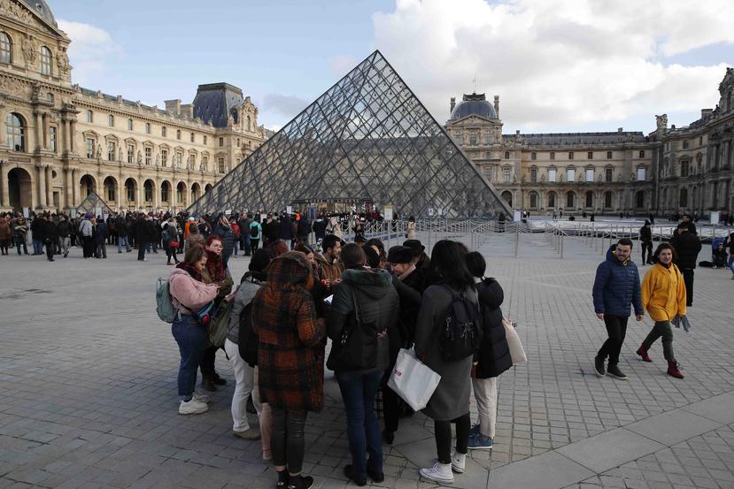 Turistas esperan y empleados en huelga se manifiestan en la entrada al Museo del Louvre. (AP/Francois Mori)