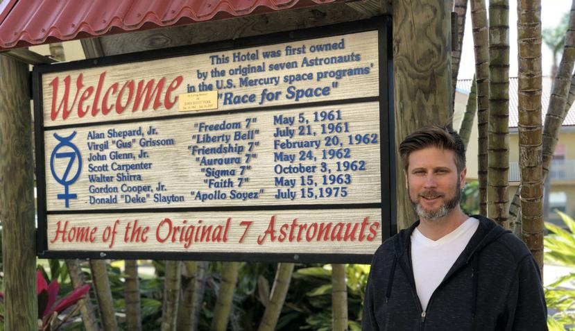El cineasta Zachary Weil, director del documental "When We Were Apollo", mientras posa junto a un cartel cercano al Centro Espacial Kennedy (EFE).