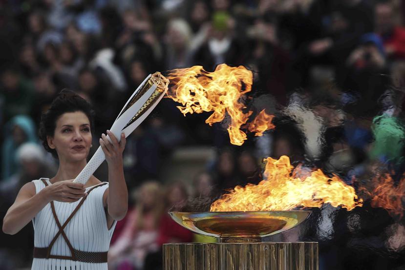 La actriz Katerina Lehou, en papel de sacerdotisa, enciende la antorcha olímpica durante la ceremonia de entrega de la llama olímpica a los organizadores de los Juegos Olímpicos de Invierno de Pyeongchang. (AP)