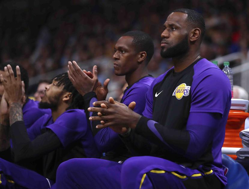 LeBron James de los Lakers, derecha, aplaude en el banco durante la primera mitad del partido de pretemporada contra los Golden State Warriors el viernes 12 de octubre de 2018, en San José, California. (AP/Ben Margot)