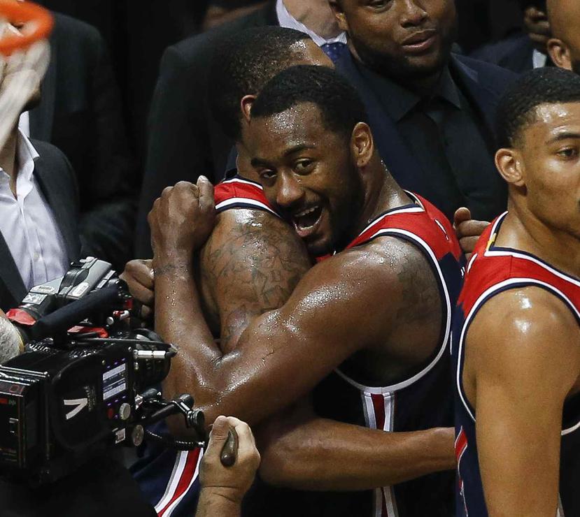 John Wall celebra el avance de los Wizards a la segunda ronda de la postemporada de la NBA con Bradley Beal. (AP)
