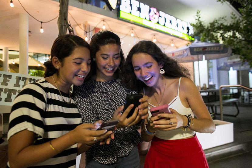 Desde la izquierda, María Rodríguez, Alondra Belaval y Alexandra Piovanetti juegan Pokémon Go frente a una heladería en Condado.