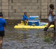 Canovanas , Puerto Rico, Septiembre 20 , 2022 - MCD -  FOTOS para ilustrar una historia sobre los estragos del paso del huracán Fiona en Loíza . EN LA FOTO una vista de la inundación ( inundacion ) en el barrio Villa Santos en Loiza - un hombre transportaba unos paquetes de botellas de agua y a un niño encima de un kayak .   FOTO POR:  tonito.zayas@gfrmedia.comRamon " Tonito " Zayas / GFR Media