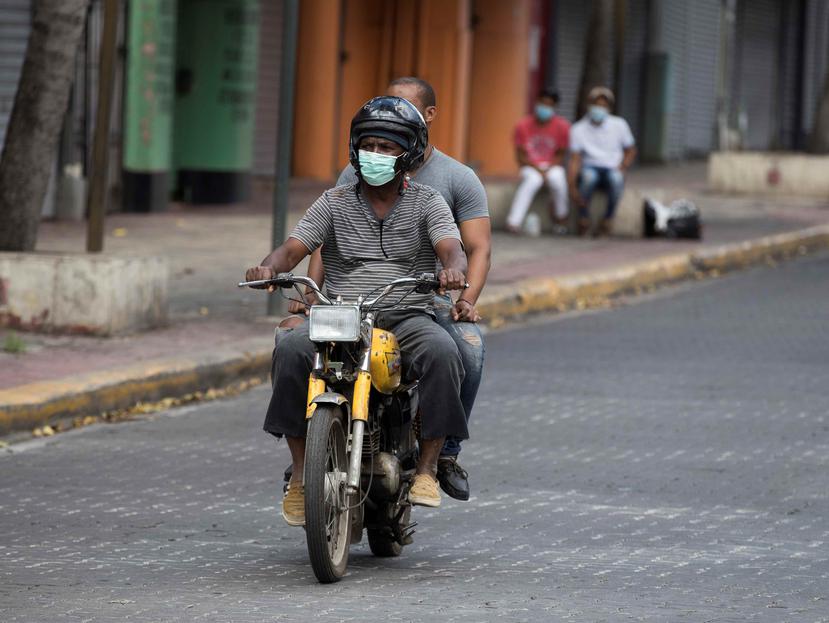 Personas protegidas con mascarillas pasean por Santo Domingo. (EFE)