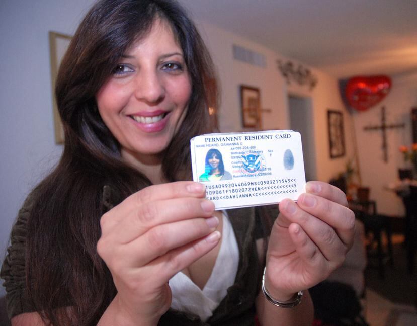 Una mujer sostiene su tarjeta del "green card". (Archivo GFR Media)