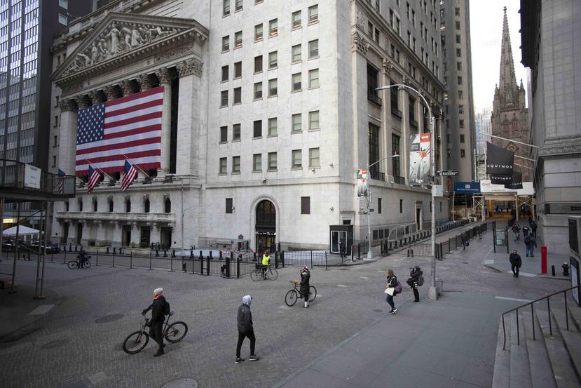 Pocas personas transitan por Wall Street, frente al edificio de la Bolsa de Valores de Nueva York, en esta foto tomada el pasado miércoles. (AP)