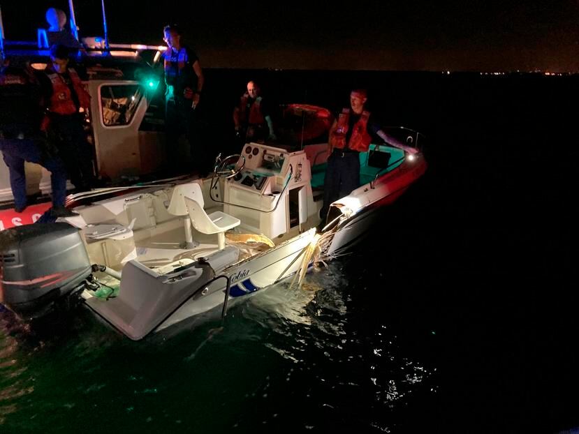 Un miembro de la Guardia Costera inspecciona una embarcación que colisionó con otra cerca de cayo Vizcaíno, en Florida.