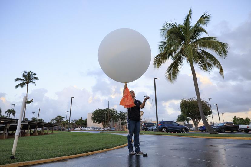 La Líder del Programa de Observación del Servicio Nacional de Meteorología en San Juan, Rosalina Vázquez, sostiene el globo con la radiosonda.