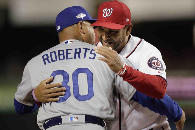El dirigente de los Nationals Dave Martínez abraza a su homólogo de los Dodgers de Los Ángeles, Dave Roberts. (AP / Julio Cortez)