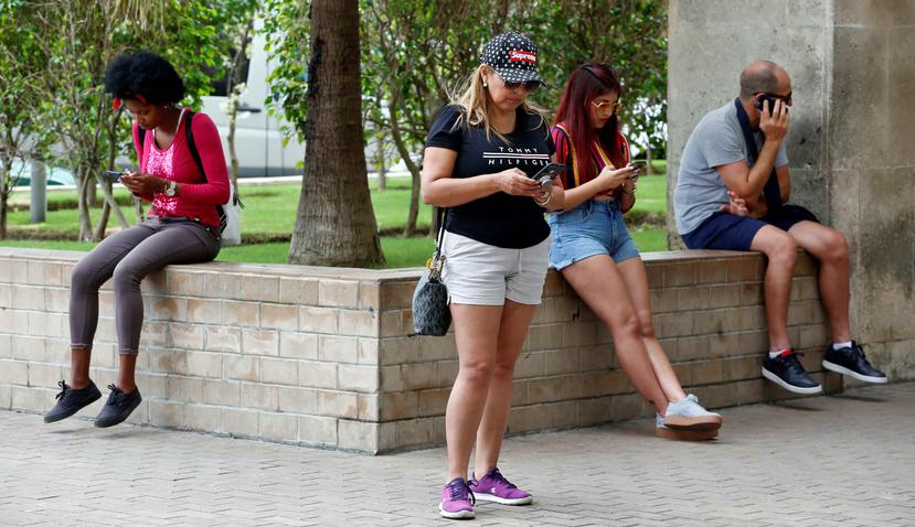 Varias personas navegan en internet con sus celulares en La Habana (Cuba).