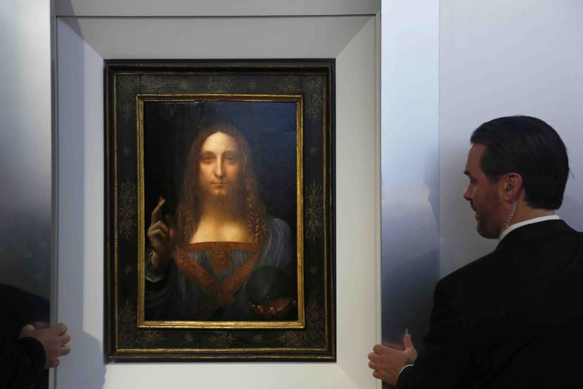 Guardias de seguridad dejan ver la obra "Salvator Mundi" de Leonardo Da Vinci durante una conferencia de prensa en Christie's en Nueva York. (AP)
