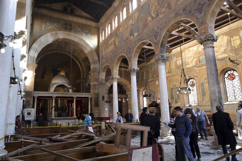 Varias personas comprueban los daños en el interior de la Iglesia de San Pedro tras el ataque de bomba. (EFE)