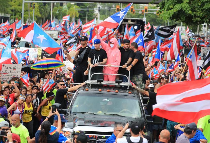 Wisin, Residente, Bad Bunny, Nicky Jam y Julián Gil desde un vehículo, participando de la marcha "Somos más".