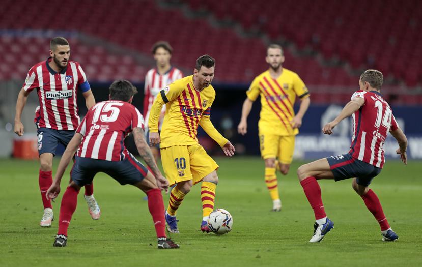 Lionel Messi es acorralado por el Atlético de Madrid durante el partido de la Liga Española.