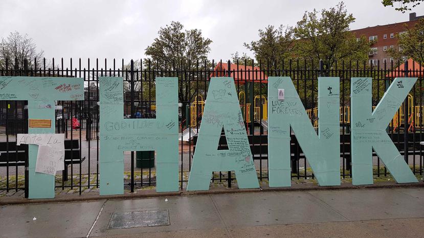 La obra consiste de ocho grandes letras mayúscula color verde amarradas a la valla de un pequeño parque con juegos para niños. (EFE)