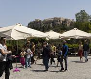 Varias personas caminan cerca de la Acrópolis, en Atenas, el 1 de mayo de 2022.