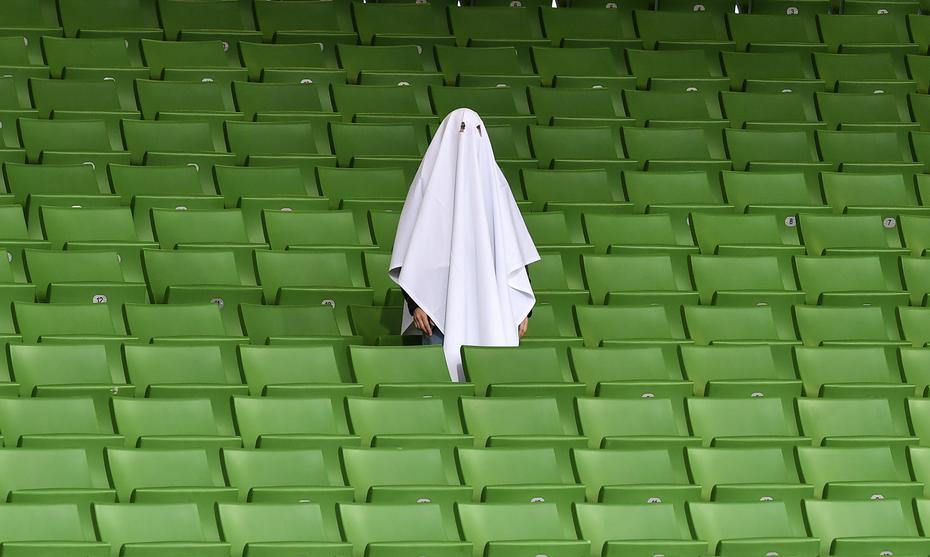 Un hombre vestido como un fantasma de pie en una tribuna vacía antes del partido de ida de los octavos de final de la Liga Europa entre Linzer ASK y Manchester United en Linz, Austria, en esta fotografía de archivo del 12 de marzo de 2020. El partido se jugó en un estadio vacío.