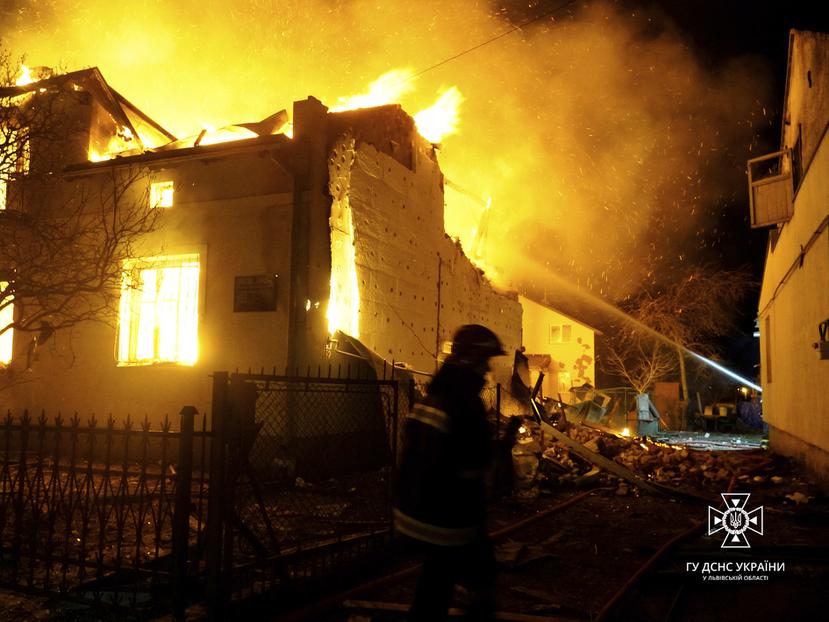 En esta imagen proporcionada por el Servicio de Emergencias de Ucrania, los bomberos trabajan para sofocar un incendio tras un ataque con drones rusos, en Dublyany, en la región de Leópolis, Ucrania, el 1 de enero de 2024.
