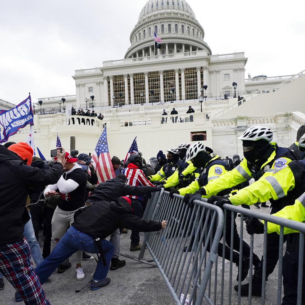 FILE - Insurrectionists loyal to President Donald Trump try to break through a police barrier, Wednesday, Jan. 6, 2021, at the Capitol in Washington. Top House and Senate leaders will present law enforcement officers who defended the U.S. Capitol on Jan. 6, 2021, with Congressional Gold Medals on Wednesday, Dec. 7, 2022, awarding them Congress's highest honor nearly two years after they fought with former President Donald Trump’s supporters in a brutal and bloody attack. (AP Photo/Julio Cortez, File)