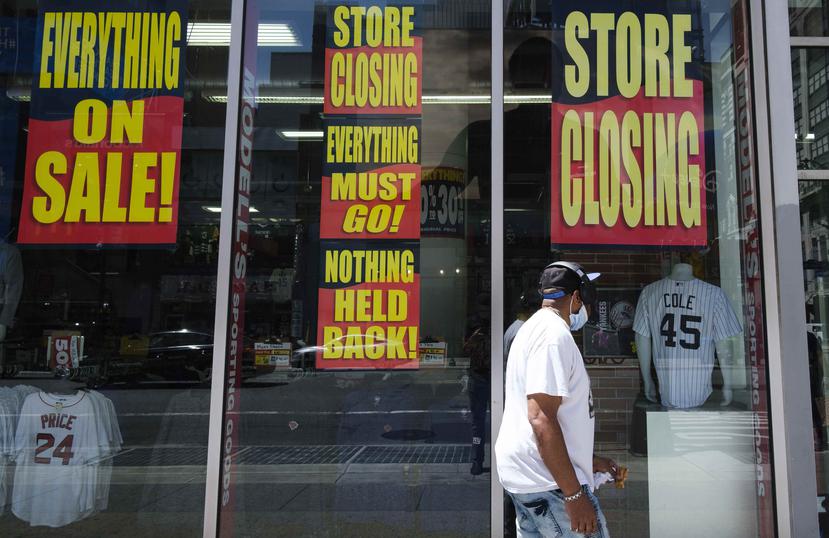 Un hombre pasa por al frente de una tienda que anuncia su cierre en Nueva York. (EFE)