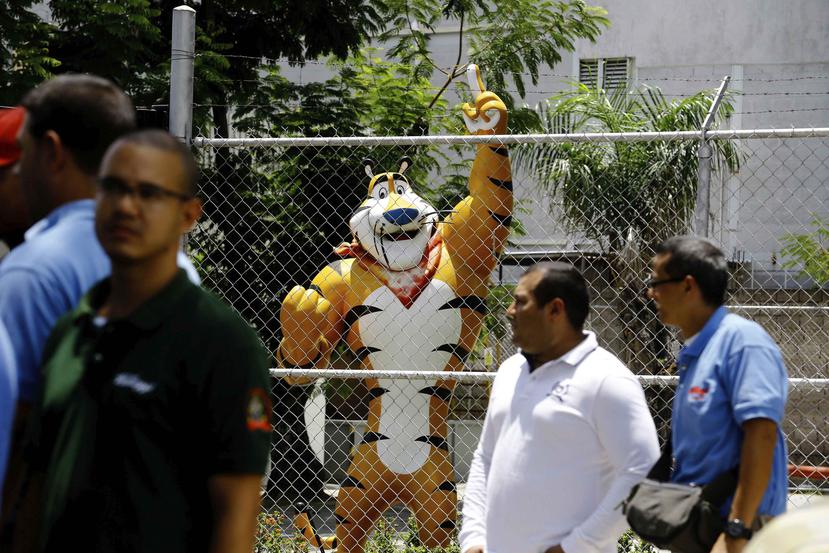 Tony el Tigre detrás de una verja de la fábrica en Maracay. (AP)