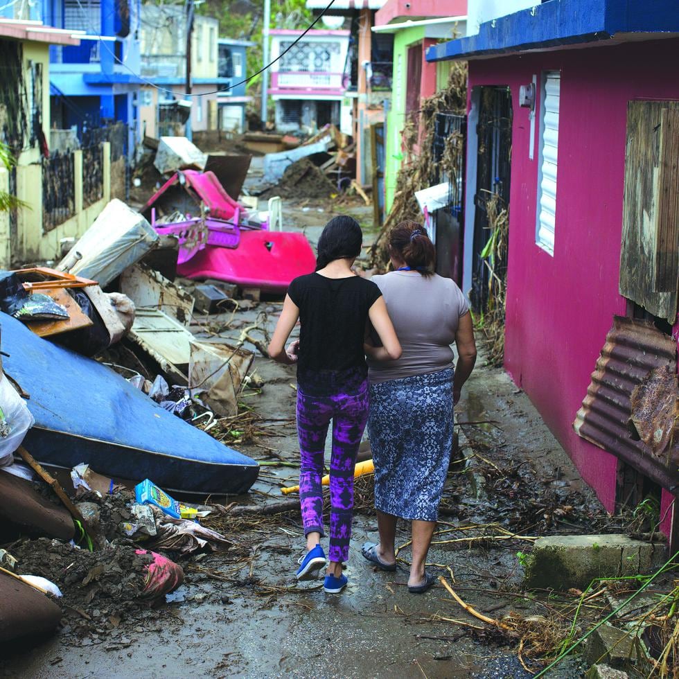 Algunas comunidades sufrieron el impacto del huracán María de manera particular. En esta foto de octubre de 2017, dos mujeres caminan entre los escombros en el sector Chichamba de Yauco.