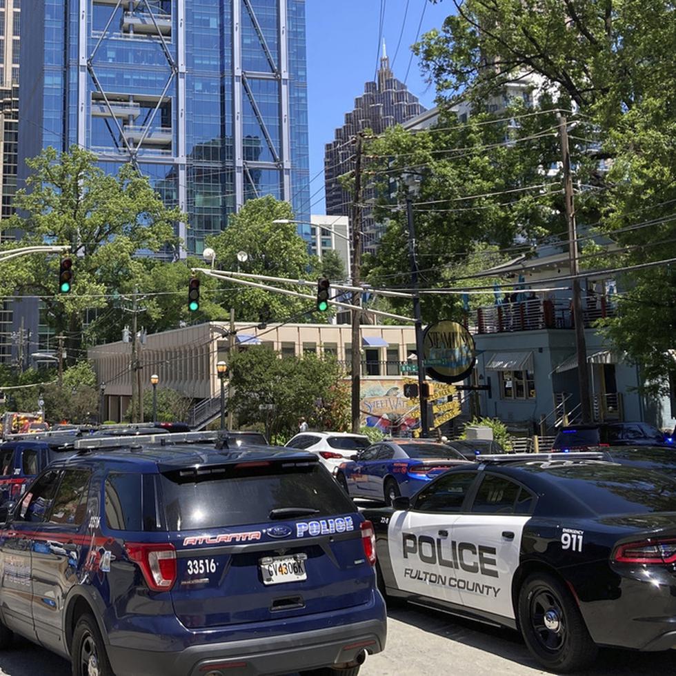 Emergency vehicles arrive on West Peachtree in Atlanta on Wednesday, May 3, 2023.  Police say are investigating an “active shooter situation” in a building in Atlanta's Midtown neighborhood and that multiple people had been injured. (AP Photo/Jeff Amy)