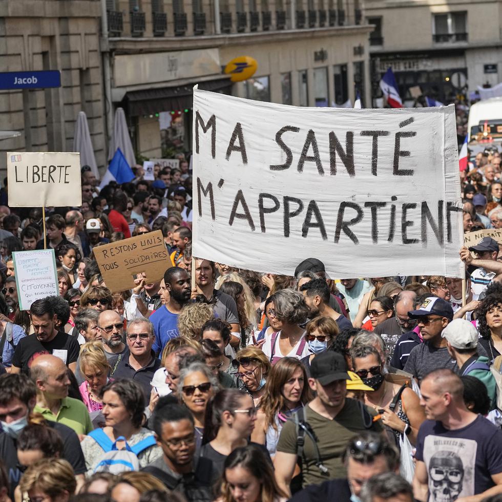 Manifestantes antivacunas desfilen en París para protestar contra las medidas más recientes del gobierno francés para combatir el incremento de infecciones con coronavirus.  (AP Foto/Michel Euler)