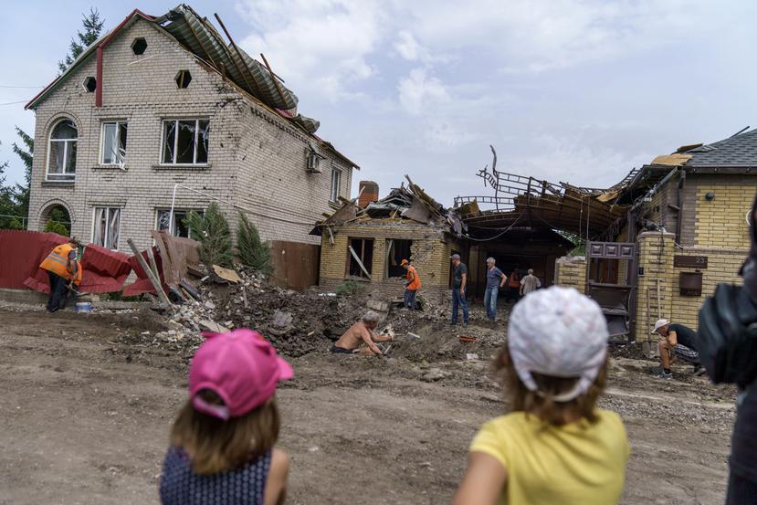 Niños observan a trabajadores que remueven los escombros tras un ataque con cohete a una vivienda en Kramatorsk, región de Donetsk, este de Ucrania.