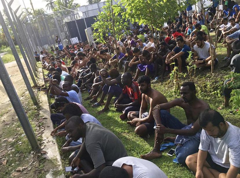 Solicitantes de asilo se sientan en el piso mientras se niegan a salir del centro de detención de la Isla de Manus en Papúa Nueva Guinea. (AP)