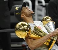 Antetokounmpo grita de alegría con los trofeos de campeonato de la NBA y Jugador Más Valioso de las Finales.