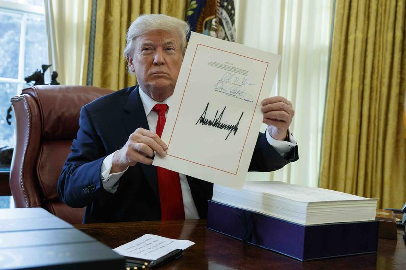 Trump enseña su firma en el proyecto. (AP / Evan Vucci)