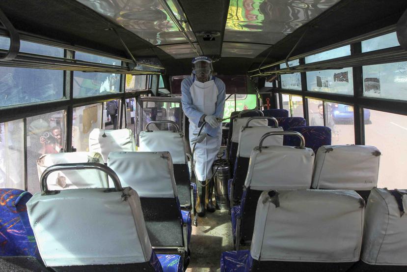 Un hombre rocía desinfectante en un autobús público para combatir la diseminación del nuevo coronavirus en Nairobi, Kenia.  (AP)