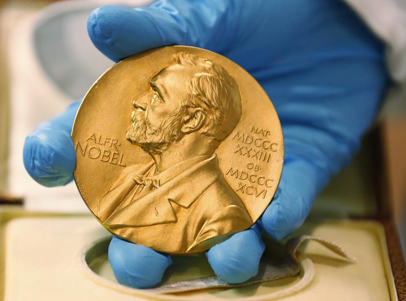 En esta imagen de archivo, un empleado de la biblioteca nacional muestra una medalla de oro del Premio Nobel.