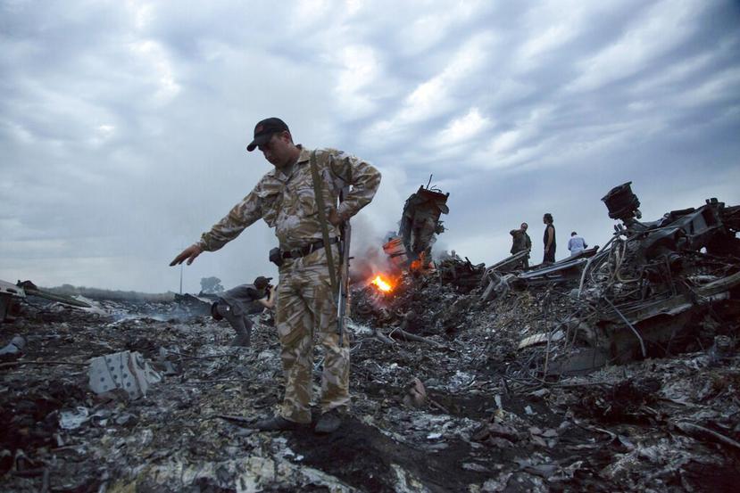 Varias personas caminan entre los escombros de un avión de pasajeros derribado, cerca de la localidad de Grabovo, en Ucrania. (AP / Archivo)