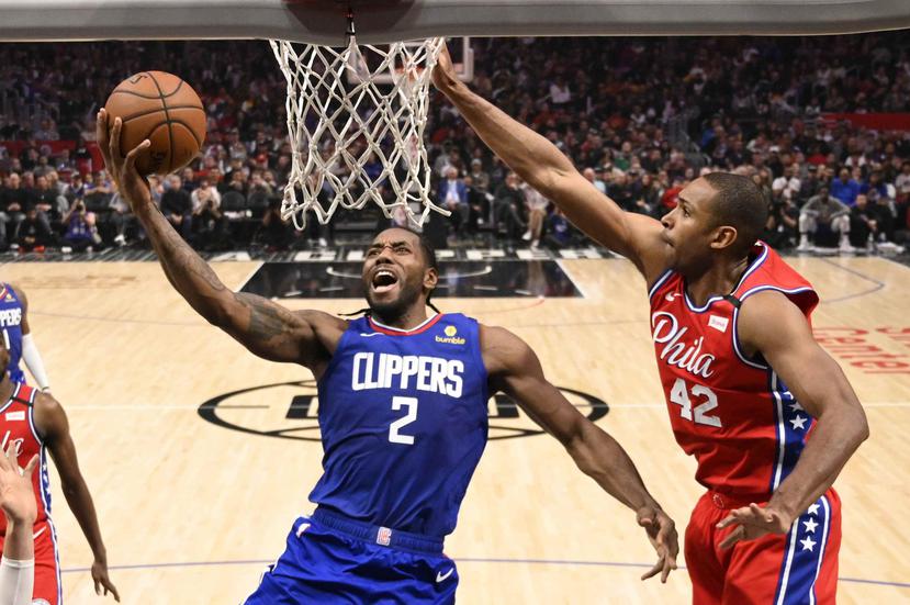 Kawhi Leonard, de los Clippers, se apresta a marcar dos puntos no empece a la gestión defensiva de Al Horford, de Filadelfia. (AP)